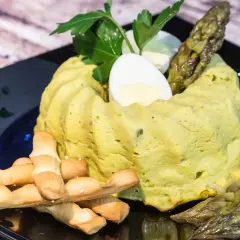 Delizioso flan di asparagi, guarnito con uovo sodo, asparagi freschi e grissini croccanti. Un piatto primaverile da gustare.