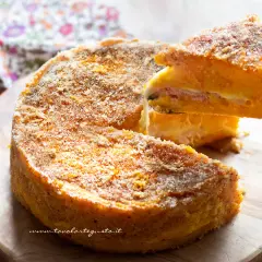 Una fetta di zucca al forno, soffice e dorata, con strati di formaggio e prosciutto, pronta per essere gustata.