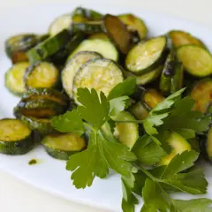 Zucchine alla poverella, fette di zucchine saltate in padella con aglio e prezzemolo fresco, un contorno semplice e gustoso.