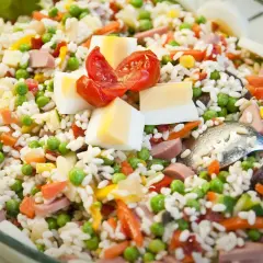Insalata di riso ricca di ingredienti: piselli, carote, uova sode, pomodorini e salumi. Perfetta per un pasto fresco e completo.