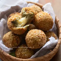 Croccanti polpette di carciofi con cuore filante di formaggio, servite in un cestino di vimini.