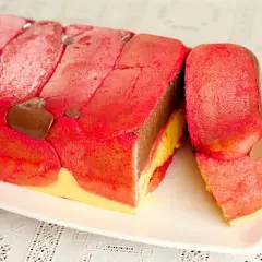 Una fetta di zuppa inglese tradizionale, con savoiardi rossi, crema al cioccolato e crema gialla.