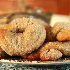 Ciambelline al vino dorate e cosparse di zucchero, un dolce profumato e croccante, perfetto per accompagnare un caffè.