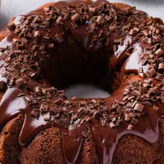 Ciambellone al cioccolato con glassa lucida e riccioli di cioccolato fondente. Un dolce invitante e goloso.