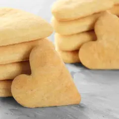 Biscotti a forma di cuore, impilati su una superficie grigia. Deliziosi biscotti senza uova, perfetti per ogni occasione.