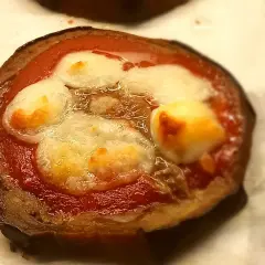 Pizzette di melanzane con pomodoro e mozzarella filante, un antipasto gustoso e leggero.