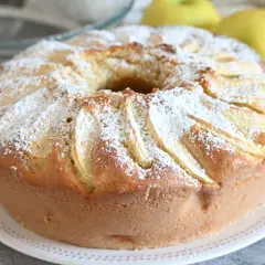 Ciambella alle mele soffice e profumata, cosparsa di zucchero a velo, con mele a vista.