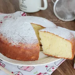 Una soffice torta yogurt greco, spolverata di zucchero a velo, pronta per essere gustata.