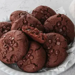Un mucchio di deliziosi biscotti al cioccolato, perfetti per chi cerca biscotti senza burro. Alcuni sono interi, altri spezzati, rivelando un interno morbido e ricco.