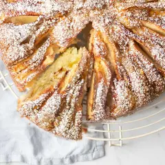 Deliziosa torta di mele in friggitrice ad aria, cosparsa di zucchero a velo, con una fetta tagliata che rivela il morbido interno.