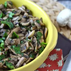 Un piatto giallo pieno di saporiti funghi in padella, guarniti con prezzemolo fresco.