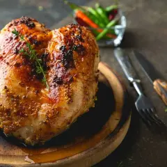Petto di pollo al forno dorato e succulento, condito con senape e erbe aromatiche, pronto per essere gustato.