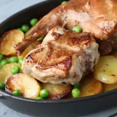 Coniglio arrosto in padella con patate e piselli, un piatto succulento e invitante.