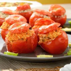 Pomodori ripieni di riso, un piatto colorato e saporito, con peperoni verdi e zucchine a guarnire.
