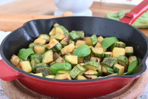 Zucchine in padella sfiziose, dorate e profumate, guarnite con foglie di basilico fresco. Un contorno semplice e gustoso.