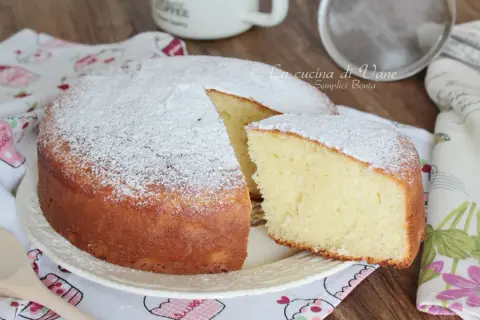 Una soffice torta yogurt greco, spolverata di zucchero a velo, pronta per essere gustata.