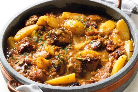 Un invitante spezzatino di manzo morbidissimo con patate, cotto lentamente in un ricco sugo e guarnito con prezzemolo fresco.