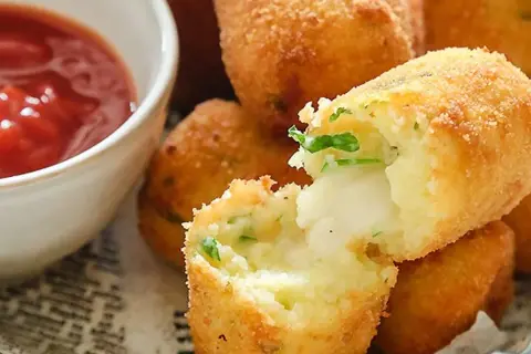 Crocchette di patate napoletane dorate e croccanti, con un cuore filante di formaggio e prezzemolo. Perfette con ketchup.