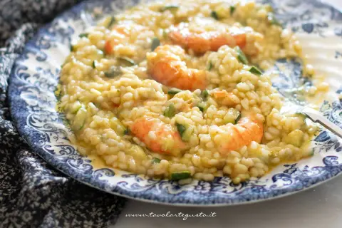 Risotto cremoso con zucchine e gamberetti, un piatto estivo da gustare.