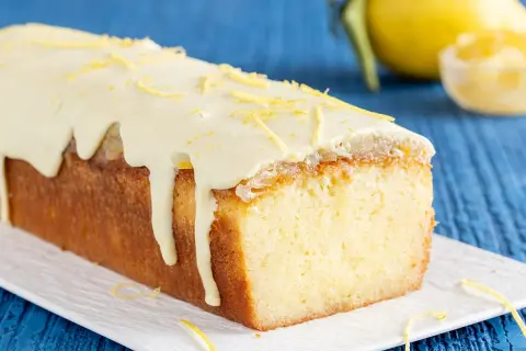Plumcake al limone con glassa bianca e scorzette gialle, un dolce profumato e invitante.
