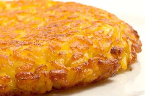 Una dorata frittata di riso, croccante fuori e morbida dentro, pronta per essere gustata.