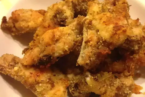 Croccante pollo alla diavola impanato e cotto al forno, con erbe aromatiche.
