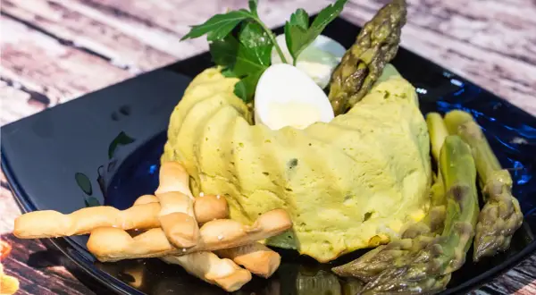 Delizioso flan di asparagi, guarnito con uovo sodo, asparagi freschi e grissini croccanti. Un piatto primaverile da gustare.