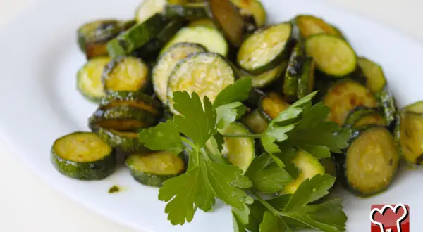 Zucchine alla poverella, fette di zucchine saltate in padella con aglio e prezzemolo fresco, un contorno semplice e gustoso.