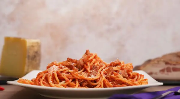 Piatto di spaghetti all'amatriciana, con guanciale croccante e pecorino. Ecco come si fa l'amatriciana, un classico della cucina romana.