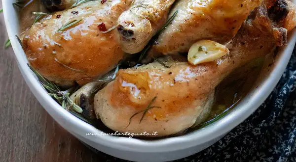 Succulente sovracosce di pollo al forno, dorate e profumate con aglio e rosmarino, servite in una ciotola bianca.