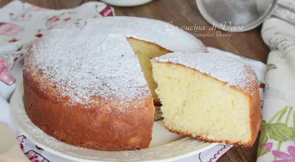 Una soffice torta yogurt greco, spolverata di zucchero a velo, pronta per essere gustata.