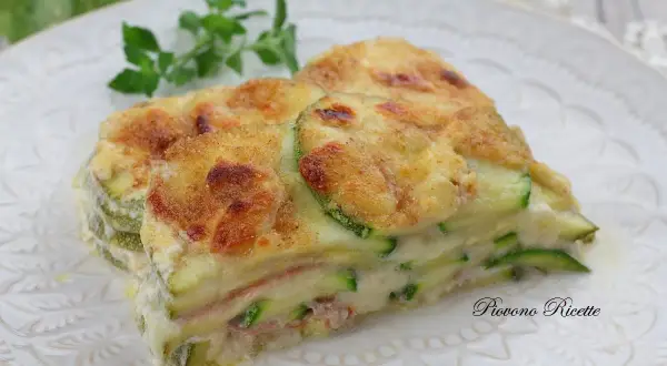 Fetta di lasagne di zucchine, stratificata con prosciutto e besciamella, gratinata al forno.