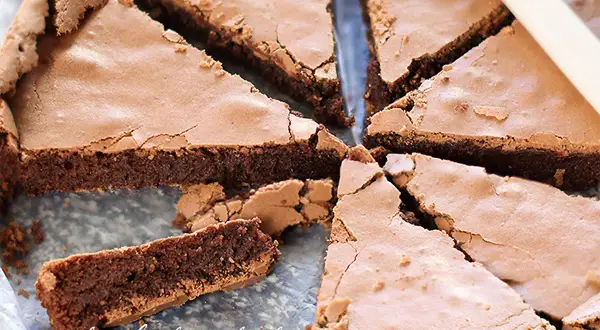 Fette di torta tenerina senza burro, con una crosticina croccante e un interno morbido e cioccolatoso.