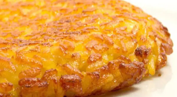 Una dorata frittata di riso, croccante fuori e morbida dentro, pronta per essere gustata.