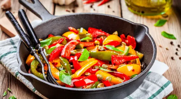 Peperoni in padella, colorati e succosi, pronti per essere gustati. Un contorno semplice e saporito.