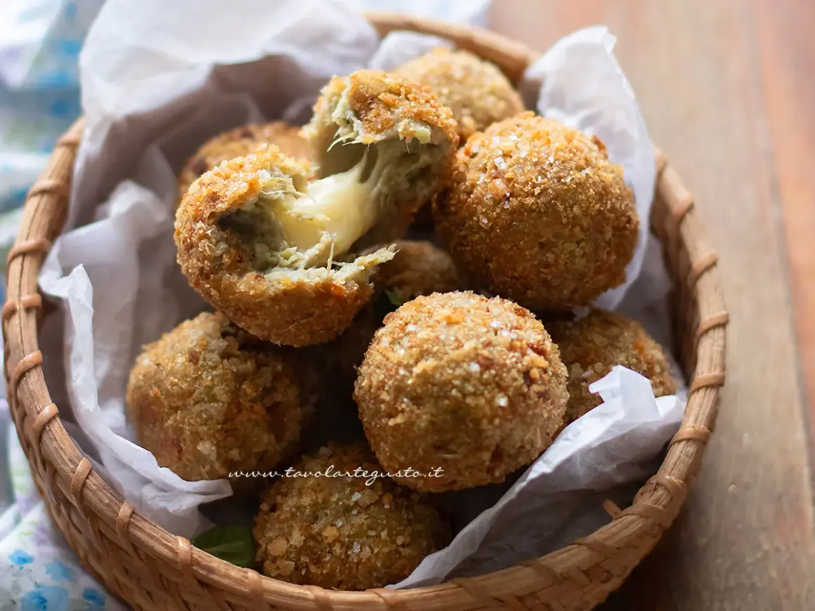 Croccanti polpette di carciofi con cuore filante di formaggio, servite in un cestino di vimini.