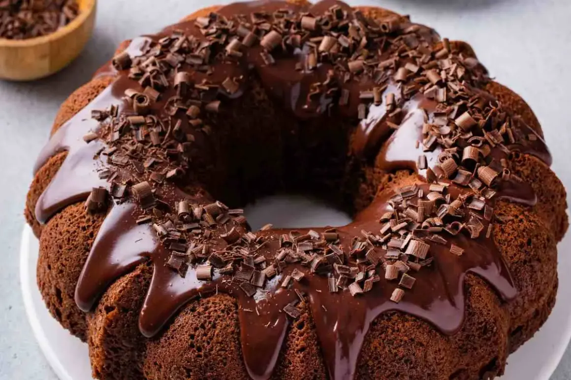 Ciambellone al cioccolato con glassa lucida e riccioli di cioccolato fondente. Un dolce invitante e goloso.
