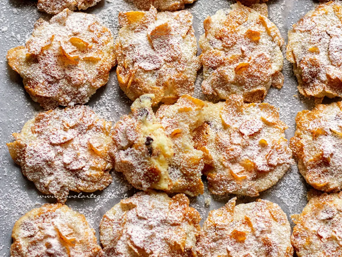 Biscotti croccanti, simili a rose del deserto, ricoperti di zucchero a velo e fiocchi di mais.