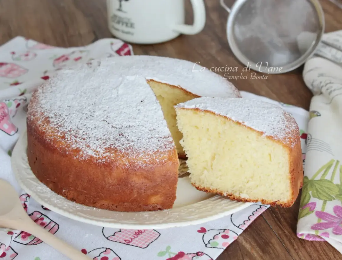 Una soffice torta yogurt greco, spolverata di zucchero a velo, pronta per essere gustata.