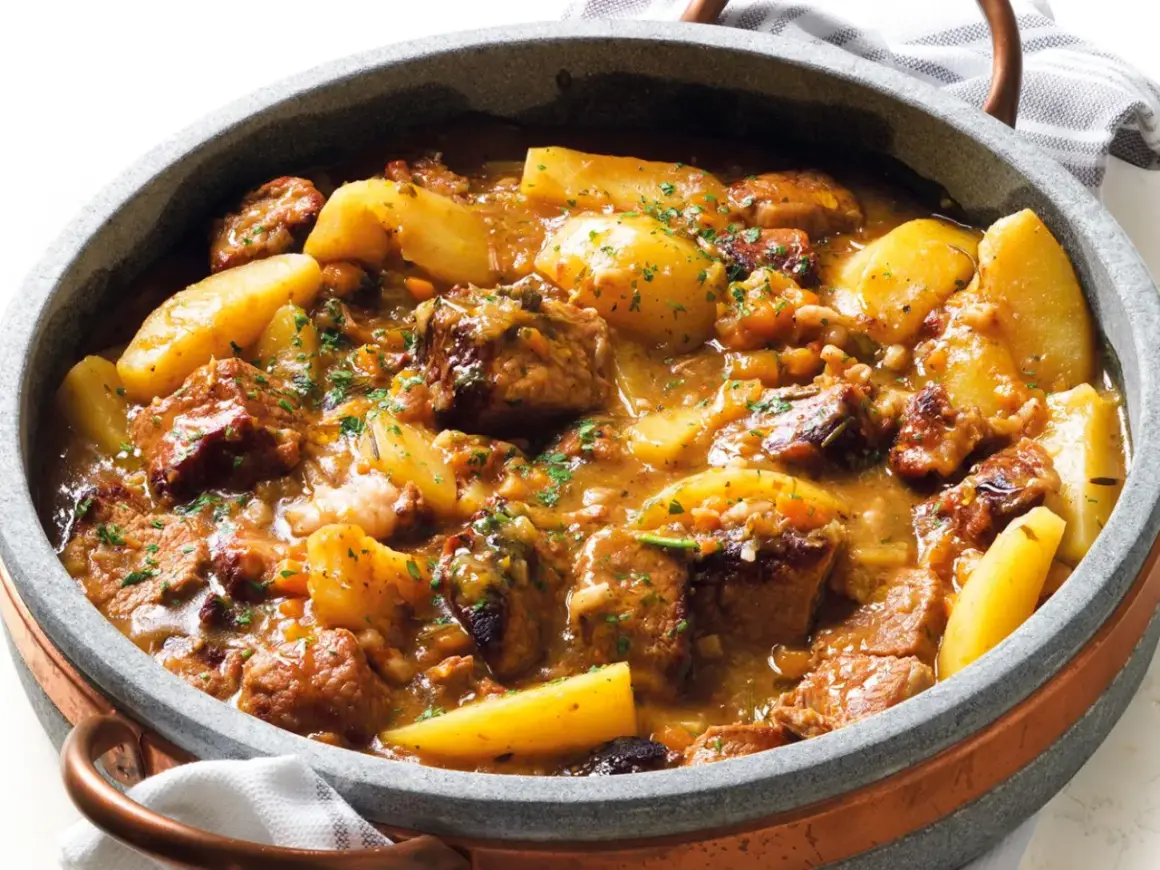 Un invitante spezzatino di manzo morbidissimo con patate, cotto lentamente in un ricco sugo e guarnito con prezzemolo fresco.