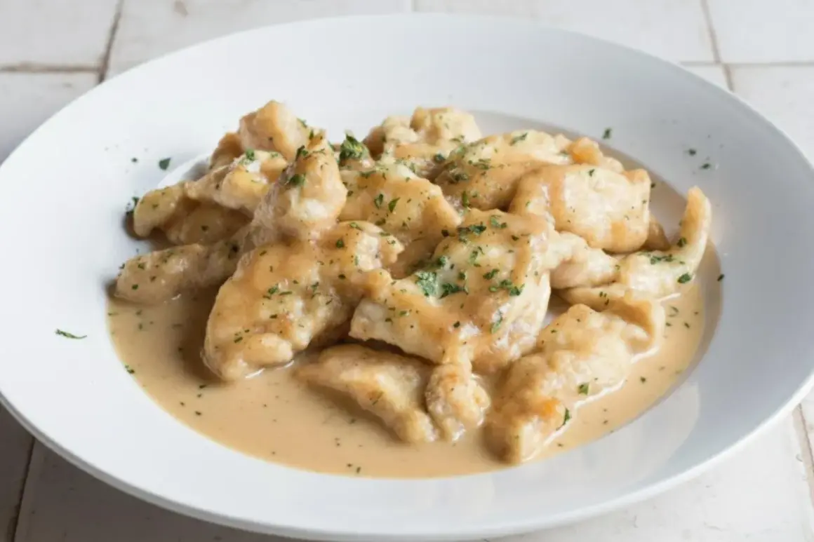 Straccetti di pollo cremosi, teneri bocconcini di pollo in una salsa vellutata, guarniti con prezzemolo tritato.