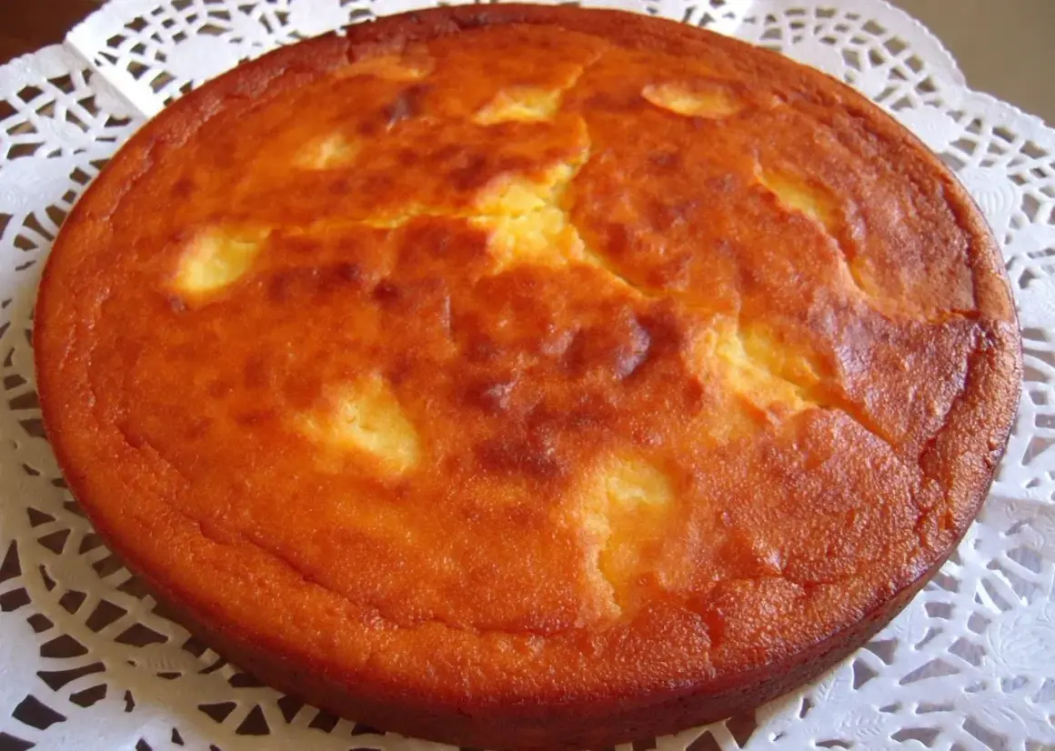 Migliaccio napoletano ricetta della nonna: una torta dorata e soffice, con la crosticina leggermente screpolata, pronta per essere gustata.