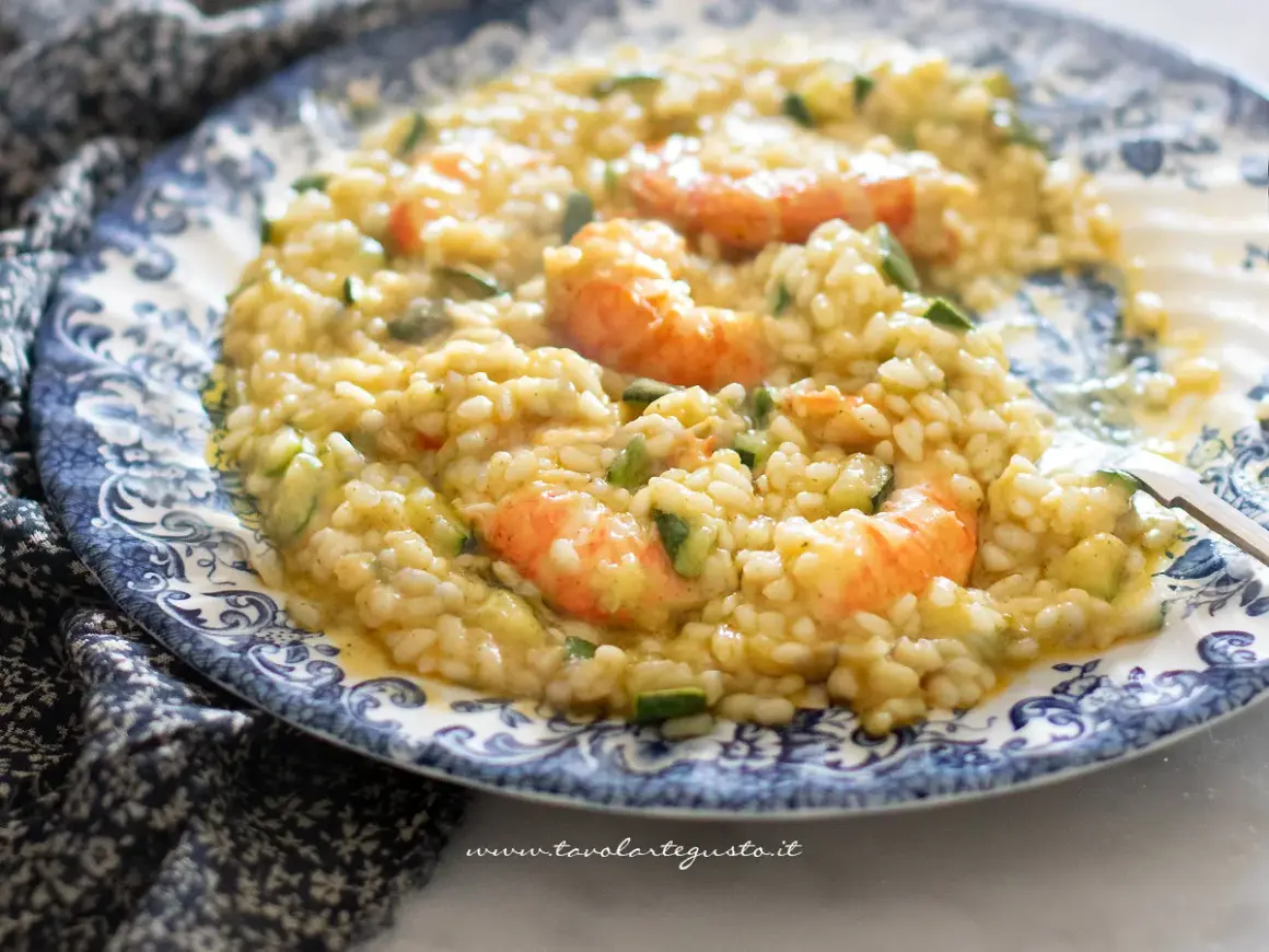 Risotto cremoso con zucchine e gamberetti, un piatto estivo da gustare.