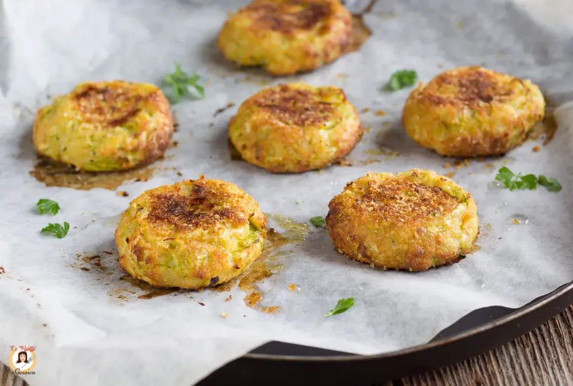 Sei polpette di zucchine dorate e croccanti, appena sfornate, su carta da forno.
