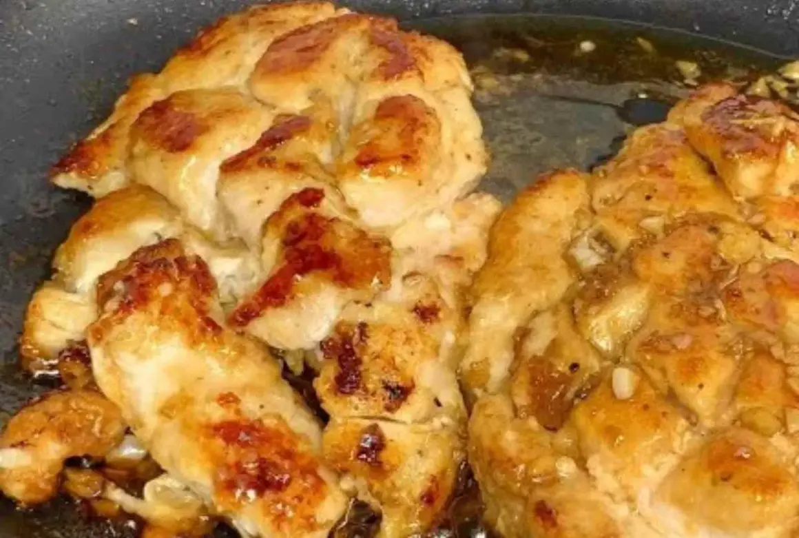 Succulento pollo in padella, dorato e saporito, con pezzetti di aglio che aggiungono un tocco in più.