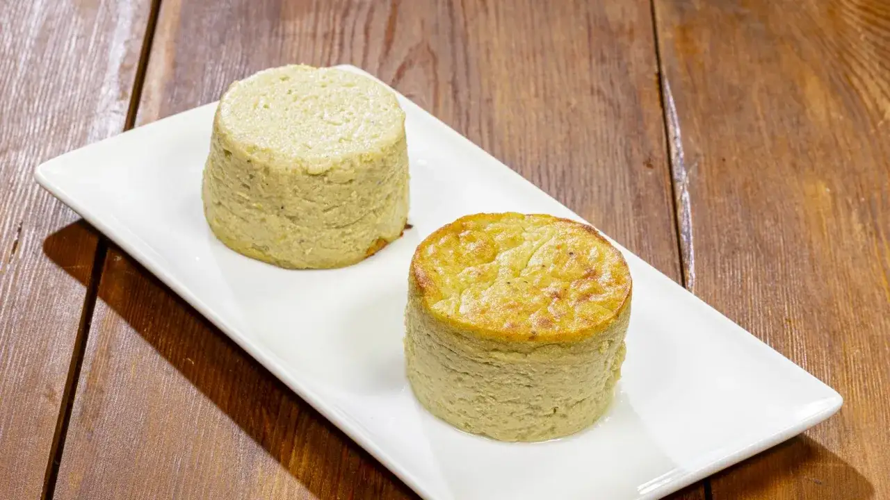 Due tortini di carciofi dorati e soffici, serviti su un piatto bianco, pronti per essere gustati.