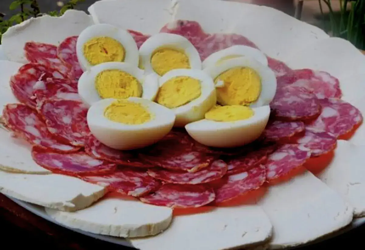 Un invitante tagliere salumi e formaggi, con uova sode a spicchi che aggiungono un tocco rustico.