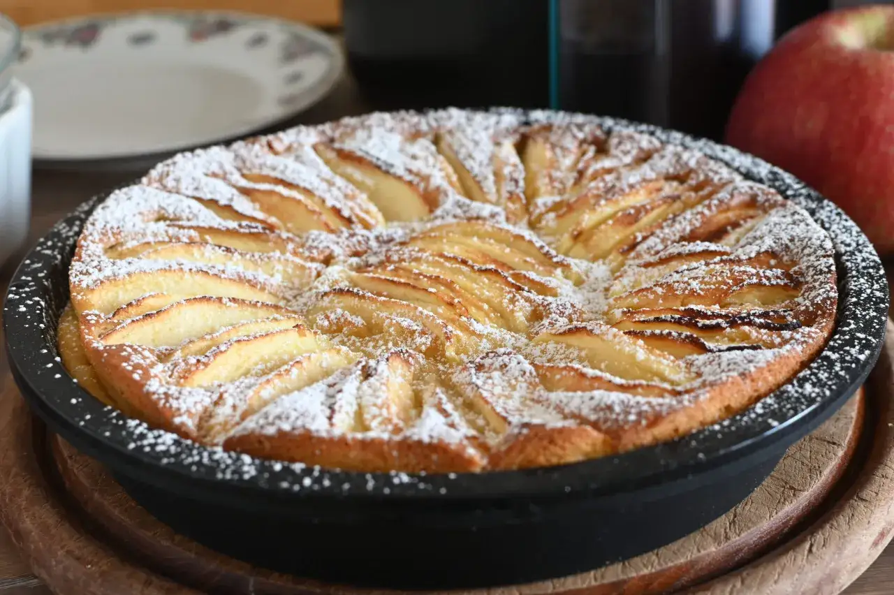 Torta di mele in friggitrice ad aria, dorata e cosparsa di zucchero a velo, pronta per essere gustata.