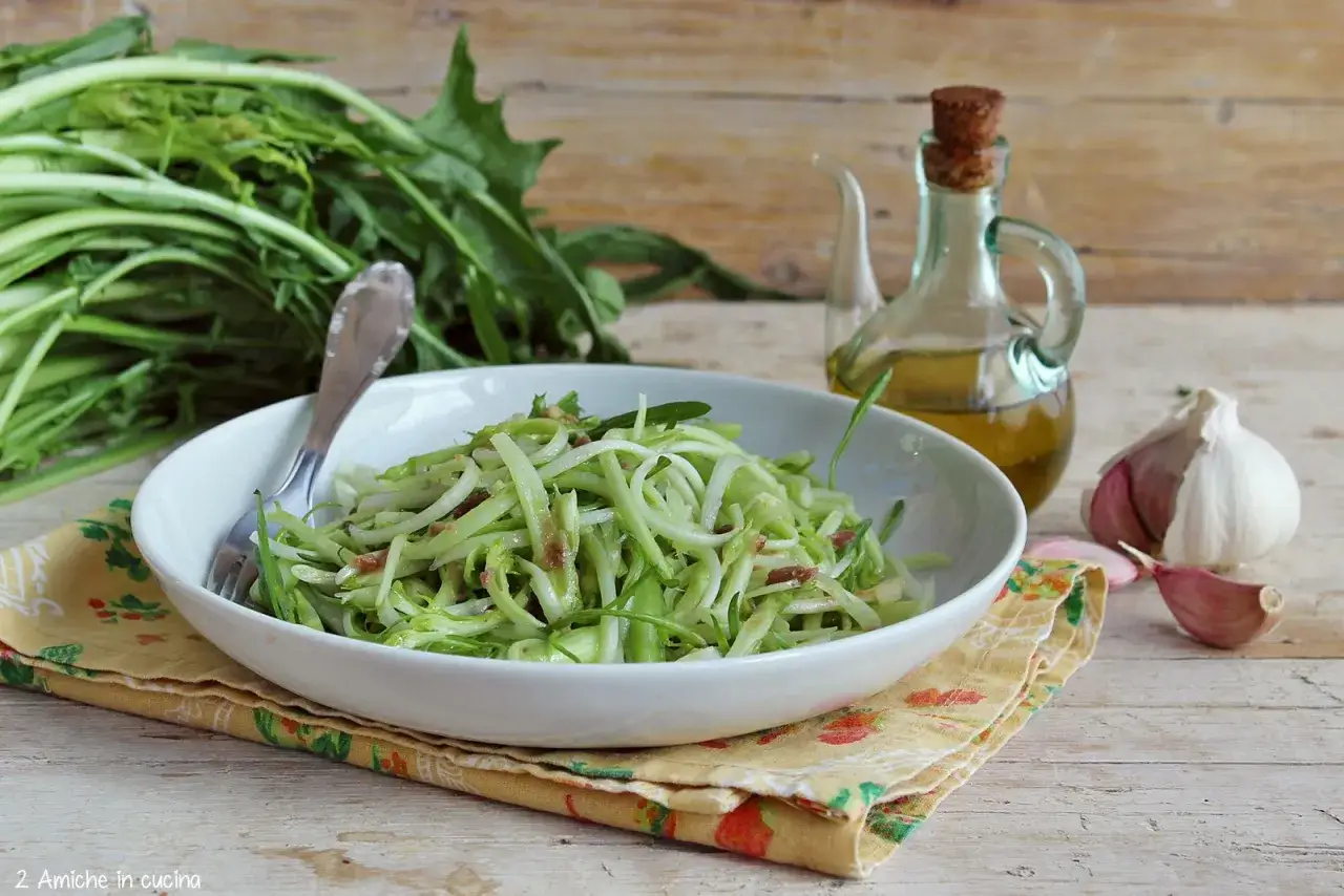 Un piatto di puntarelle alla romana, condite con olio e aglio, pronte per essere gustate.