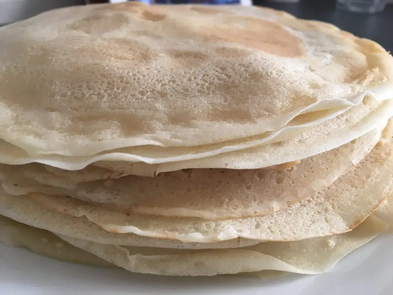 Pila di crepes senza uova, dorate e soffici, pronte per essere farcite.